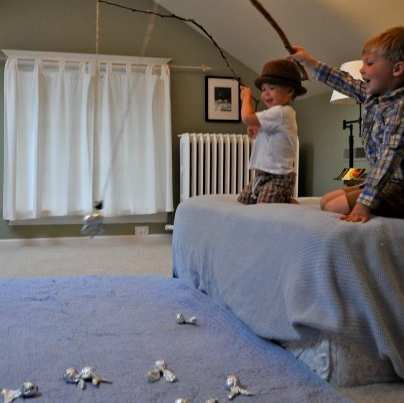 2 kids on the bed playing aluminum foil fishing