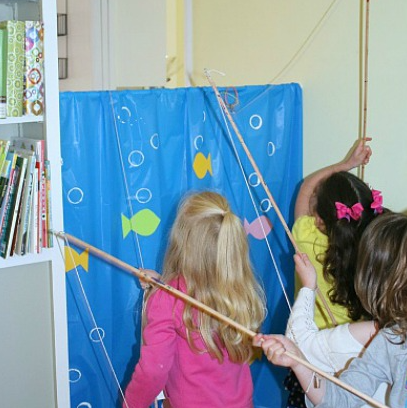 kids holding a stick with a string for magnet fishing game